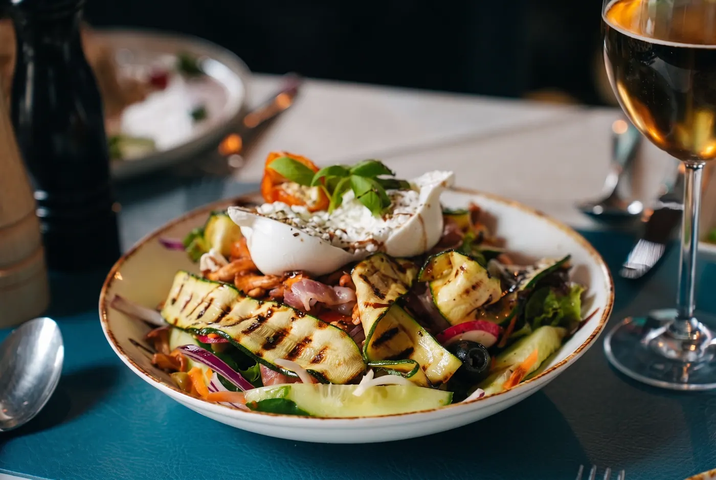 Salat mit Burrata und einem Glas Weißwein